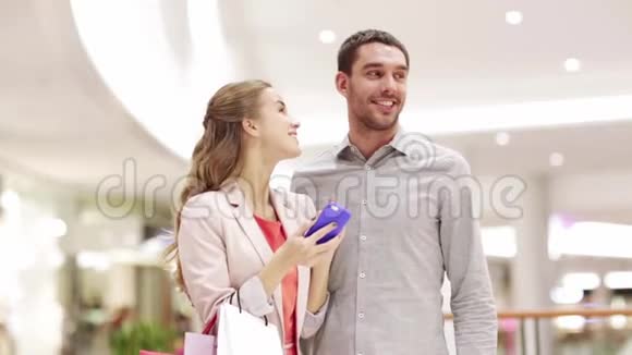 带着智能手机和购物包的情侣视频的预览图