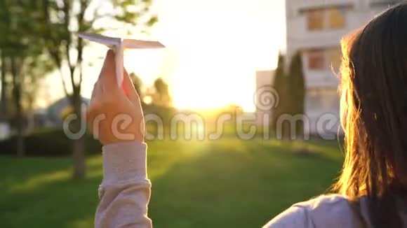 女人在日落的背景下发射纸飞机慢动作视频的预览图