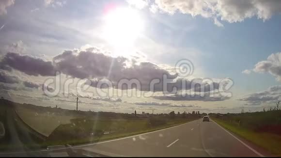 日落时的沥青路与模糊汽车卡车在美丽的春日乡村里开着柏油路视频的预览图
