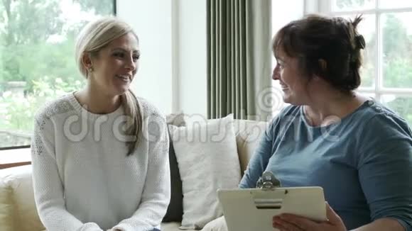 健康访客在家与妇女交谈视频的预览图