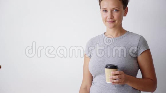 英俊的女人带着杯子慢动作商业镜头视频的预览图