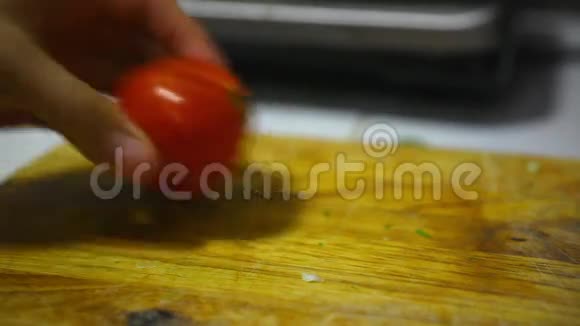 女性手拿刀切鲜红色西红柿视频的预览图