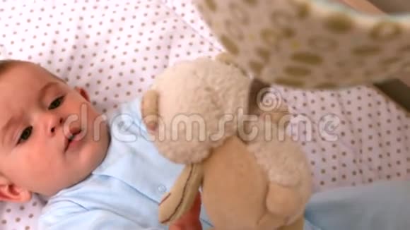 婴儿在婴儿床上玩手机视频的预览图