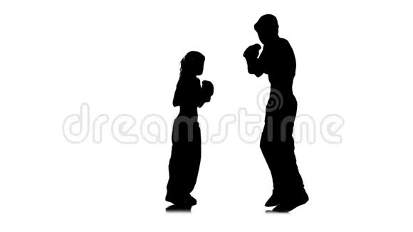 女孩在踢他们为踢拳击而争吵的家伙剪影白色背景慢动作视频的预览图