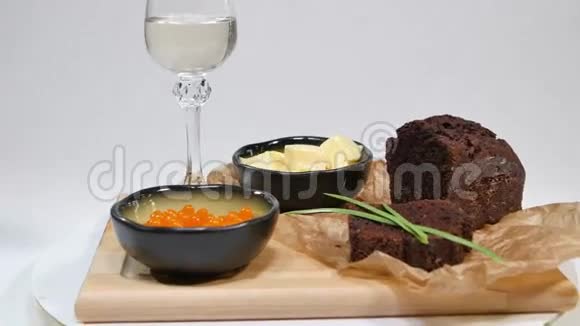 新鲜的红鱼子酱罗勒和黄油面包在工作室红色鱼子酱背景上有酒杯寒冷视频的预览图