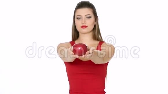 女人拿着红色的苹果在白色的背景上微笑视频的预览图