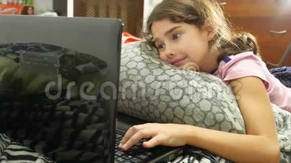 小女孩在笔记本电脑上玩网络游戏笔记本电脑视频的预览图
