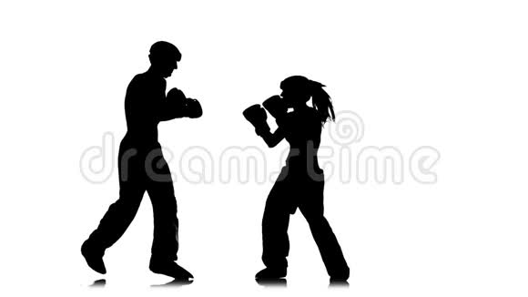 女孩在踢他们为踢拳击而争吵的家伙剪影白色背景慢动作视频的预览图