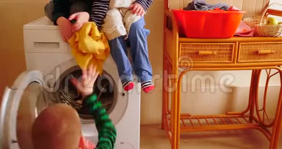 父母购买新型号最新一代洗衣机孩子们试着打开洗衣机洗一些衣服视频的预览图