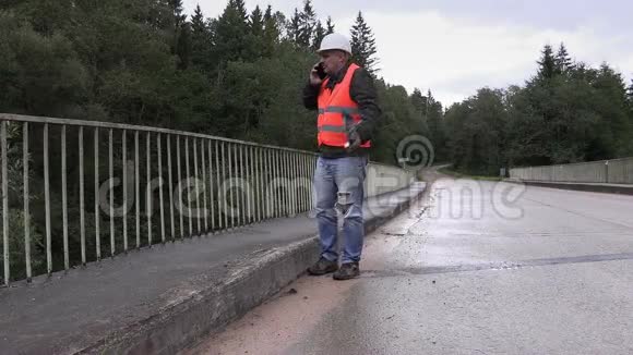 在桥上打手机的工人视频的预览图