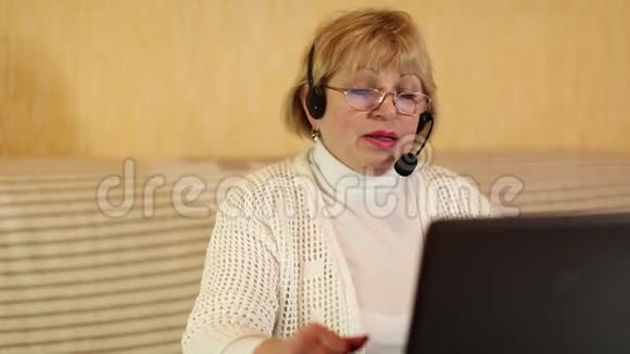 带麦克风耳机的女士通过电脑与顾客交谈视频的预览图