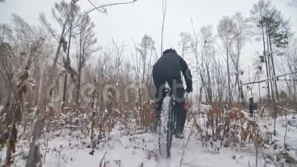 专业的极限运动员骑自行车在户外骑胖自行车后轮的近距离观察冬天骑自行车视频的预览图