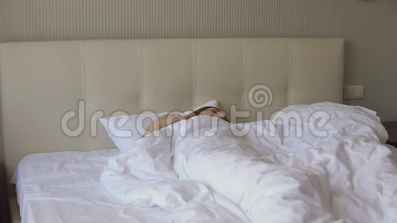 年轻的女人在床上醒来视频的预览图