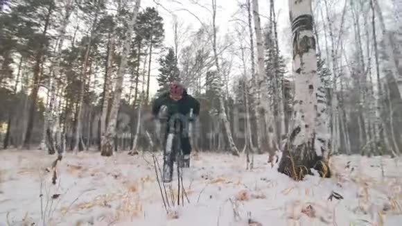 专业的极限运动员骑着一辆肥胖的自行车在户外骑自行车在冬天的雪林里人类视频的预览图