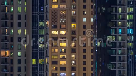 在多层现代玻璃和金属住宅建筑的发光窗口在夜间时间推移视频的预览图