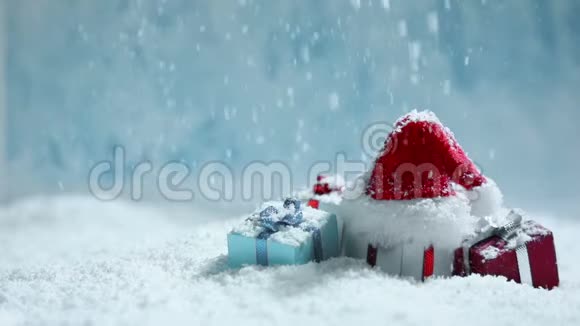 圣诞老人帽子和礼物在雪地里视频的预览图