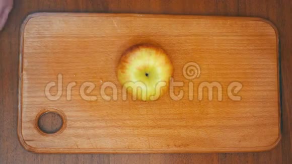 女人的手与刀切苹果在木制厨房板在家庭厨房视频的预览图