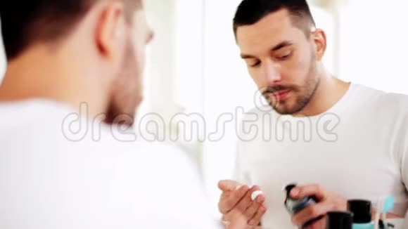在浴室用剃须泡沫刮胡子的人视频的预览图