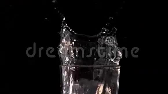 黑色背景下的冰块落入水中视频的预览图