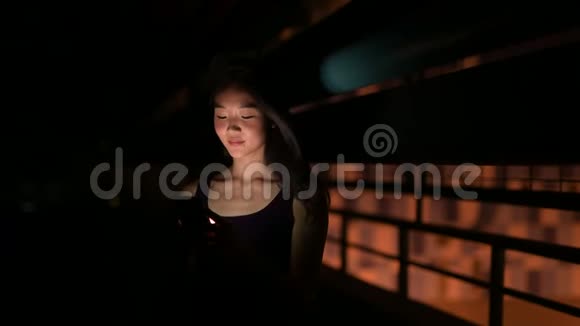 晚上在户外使用手机的美丽的亚洲女人视频的预览图