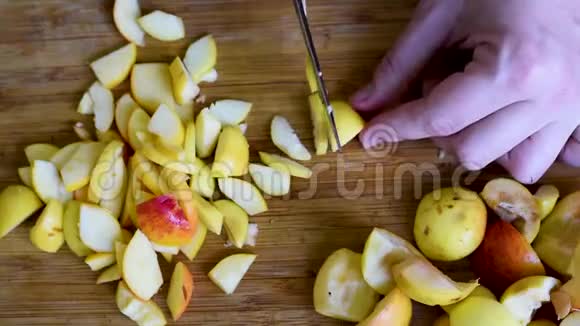 把苹果切成薄片用刀子在木板上切成两半视频的预览图