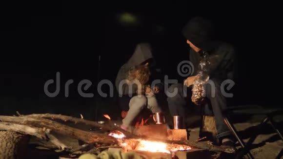 孩子们微笑孩子们喝茶青少年坐在篝火旁的生活方式晚上篝火旅行徒步旅行冒险露营视频的预览图