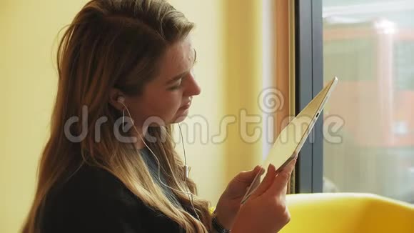 一位商务女性坐在咖啡馆的桌子旁喝着咖啡正在制作平板电脑视频的预览图