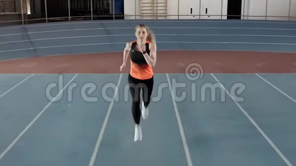 性感金发女人在室内体育场奔跑视频的预览图