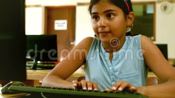 可爱的小学生在教室里看笔记本电脑视频的预览图