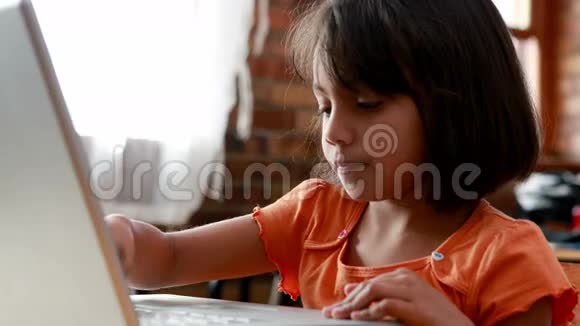 小女孩在教室里用笔记本电脑视频的预览图
