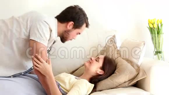可爱的一对夫妇躺在沙发上拥抱视频的预览图