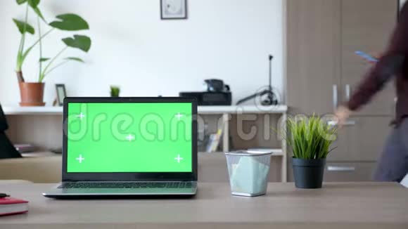 书桌上有一个绿色屏幕的笔记本电脑视频的预览图