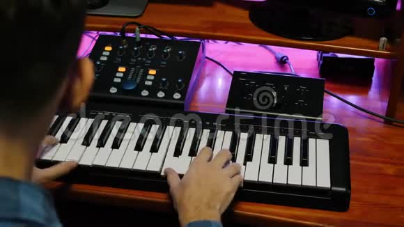 数字音频工作站家庭录音室音乐家演奏钢琴MIDI键盘与显示器混合齿轮声音视频的预览图