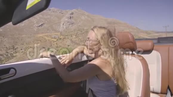 女性驾驶可兑换汽车视频的预览图