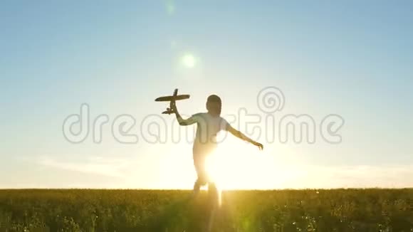 孩子们玩玩具飞机快乐的女孩带着玩具飞机在夕阳下的田野上奔跑少年梦想视频的预览图