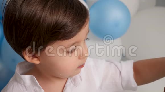 两岁的男孩带着一辆车吃一个喜庆的蓝色蛋糕视频的预览图