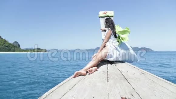 美丽的女人坐在泰国的船鼻子在海后景下年轻的女孩视频的预览图