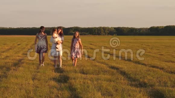 幸福家庭的观念母亲和小女儿和姐妹牵着手在公园里散步孩子和妈妈视频的预览图