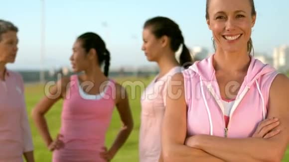 微笑的女人在朋友面前穿着粉红色的乳腺癌视频的预览图