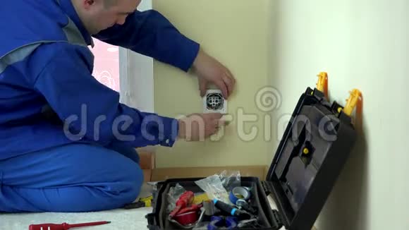 工人电工修理公寓的插座视频的预览图