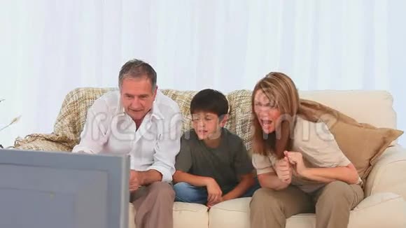 家人在电视上看比赛视频的预览图