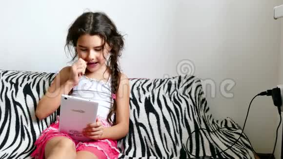 坐在床上玩平板电脑游戏的少女上网视频的预览图