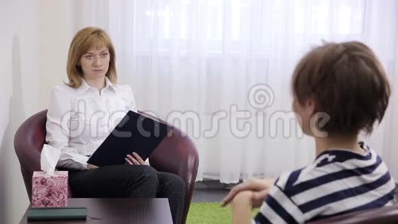 女性心理学家在心理治疗期间做笔记伤心的女孩视频的预览图