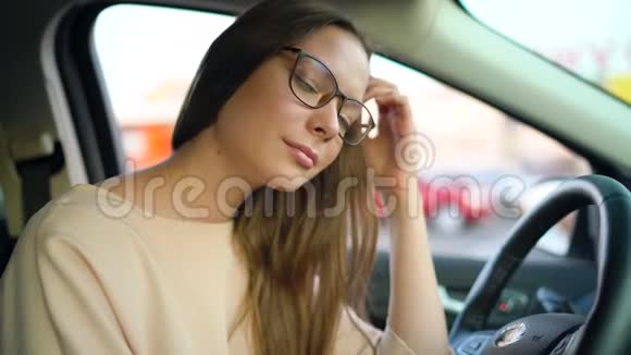 一个戴眼镜的漂亮女孩在车里的肖像视频的预览图