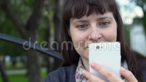 一个年轻女人使用智能手机的肖像她自拍视频的预览图