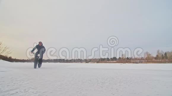 专业的极限运动员骑自行车在户外骑胖自行车骑自行车在冬天的雪林里男人是审判视频的预览图