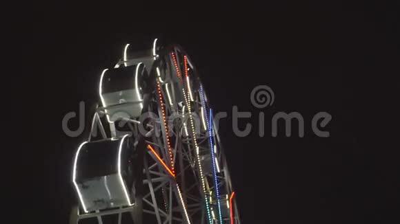 摩天轮在漆黑的夜空下旋转着游乐园视频的预览图