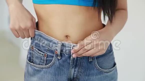 女人展示了她的减肥穿着牛仔裤视频的预览图