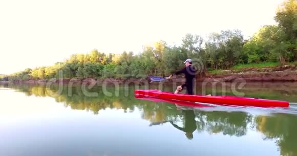 皮艇上的运动划船那个人沿着树林沿着河漂下来视频的预览图