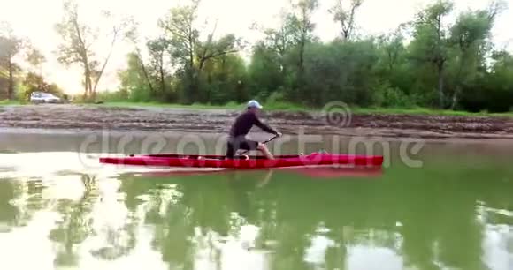 皮艇上的运动划船那个人沿着树林沿着河漂下来视频的预览图